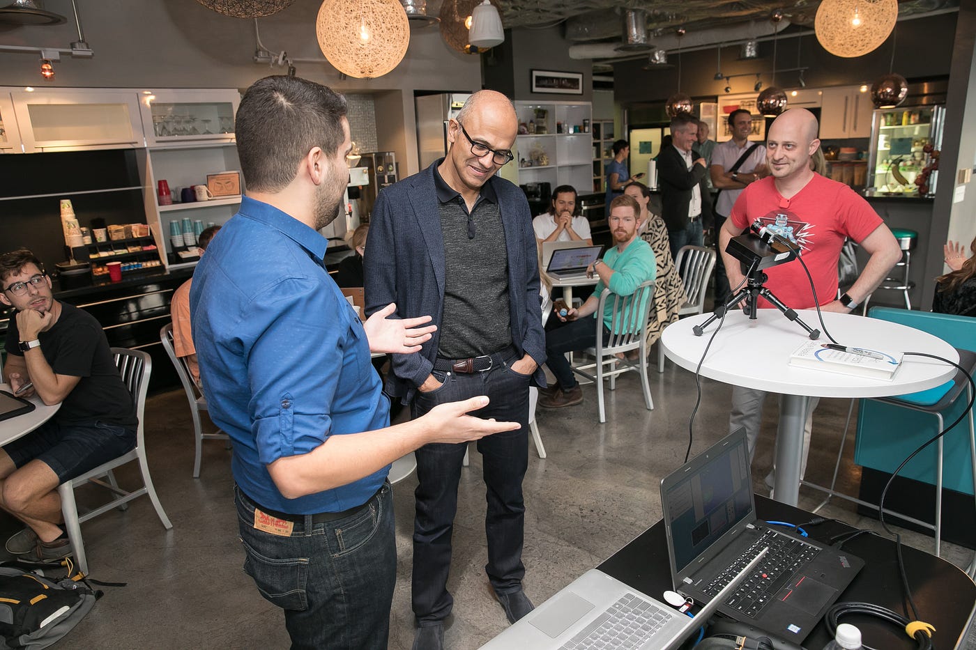 At right, in the red Capital Factory tee, with Satya Nadella at a founder demo at Capital Factory.